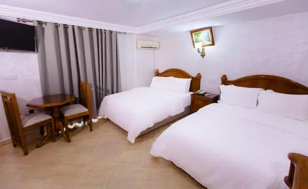 Another Triple at Hôtel Lynx: a large double and a single bed, a small round table with two chairs.